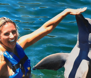 Happy Lady Touches Dolphin Mexico