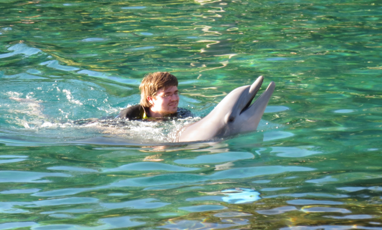 guy_riding_dolphin_close_up - Swimming with Dolphins 1-800-667-5524